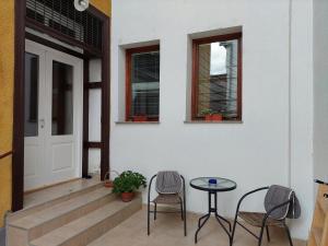 un porche con 2 sillas, una mesa y una puerta en Apartment Honey Free Parking en Sarajevo