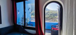 Habitación con ventana y vistas a la montaña. en Riad El Palacio & Spa Chaouen, en Chefchaouen