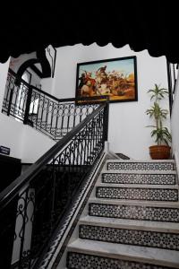 eine Treppe mit Gemälden an der Wand in der Unterkunft Riad El Palacio & Spa Chaouen in Chefchaouen