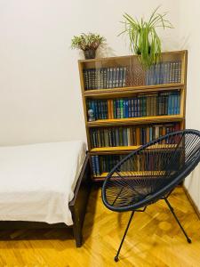 a chair next to a book shelf with books at At Nana's in Lagodekhi