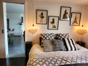 een slaapkamer met een bed en wat foto's aan de muur bij Flor'Ever en Champagne in Fleury-la-Rivière