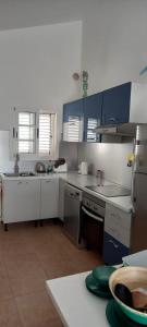 a kitchen with white counters and blue cabinets at Sunny Bungalow in Caleta De Fuste
