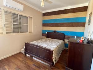 a bedroom with a bed and a striped wall at Apart. centro Ribeirão Hospital São Lucas in Ribeirão Preto