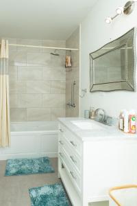 a bathroom with a sink and a tub and a mirror at La Vue de Basseterre Apartments - Luxury in Bird Rock in Basse Terre Town