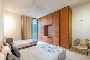 a hotel room with two beds and a chair at Casa Libre - Incredible huge condo with private pool and terrace in Aldea Zama by StayPodio 301 in Tulum +34 photos