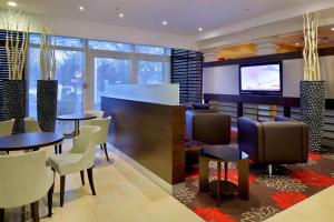 a restaurant with tables and chairs and a flat screen tv at Courtyard by Marriott Hannover Maschsee in Hannover