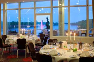 a room with tables and chairs and a large window at Courtyard by Marriott Hannover Maschsee in Hannover