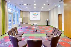 a conference room with chairs and a projection screen at Courtyard by Marriott Hannover Maschsee in Hannover