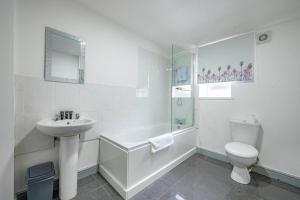 a white bathroom with a sink and a toilet at *2a* ground floor house setup for your most amazing & relaxed stay + Free Parking + Free Fast WiFi in Beeston