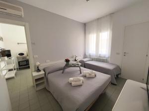 a bedroom with two beds and a table with towels at Residenza Clelia Riccione in Riccione