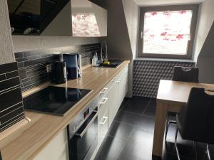 a small kitchen with white cabinets and a window at Ferienwohnung in Essen in Essen
