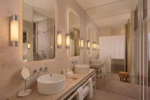 a bathroom with two sinks and two mirrors at The Ivens Autograph Collection in Lisbon
