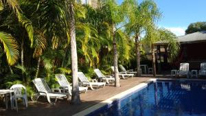 a group of lounge chairs next to a swimming pool at Pousada Morro do Rosa in Praia do Rosa