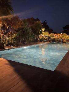 ein großer blauer Pool in der Nacht in der Unterkunft Appartement de standing avec piscine et plage à pieds in La Croix-Valmer