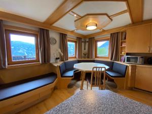 Budamerhof في فيرجن: غرفة معيشة مع طاولة وكراسي ونوافذ