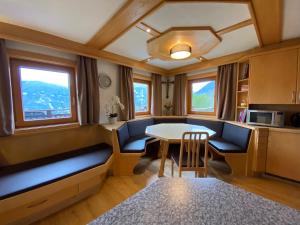 a living room with a table and chairs and windows at Budamerhof in Virgen