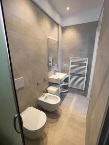 ein Badezimmer mit zwei Waschbecken, einem WC und einem Spiegel in der Unterkunft Residenza Clelia Riccione in Riccione