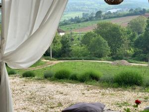 una vista de un campo desde el interior de una ventana en Nina en Arandjelovac