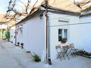 um edifício branco com cadeiras e uma mesa numa rua em Twins Boutique Korsy em Sibiu