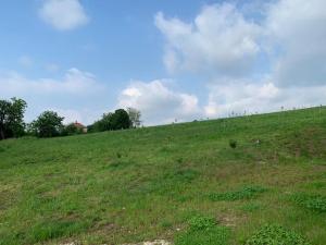 une colline herbeuse avec un ciel bleu et des nuages dans l'établissement Nina, à Aranđelovac
