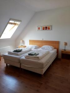 a bedroom with two beds in a attic at Uut in Thuus in Buren