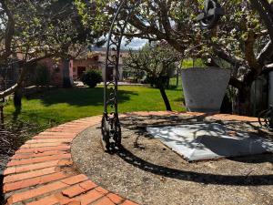 une balançoire dans un jardin avec un chemin en briques dans l'établissement El Rinconcito de Cinderellana, 