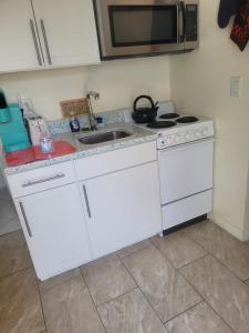 uma cozinha com um fogão branco e um lavatório em ~ Cozy In-law Apartment Close to Siesta Key ~ em Sarasota
