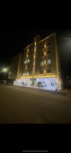 a large building at night with cars parked in front at مساكن ميرنا in Taif