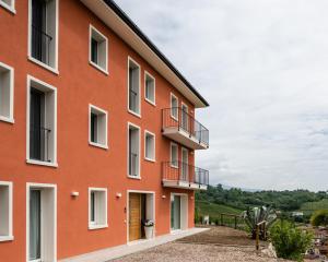 an orange building with balconies on the side at Agriturismo al Comarel in Tarzo