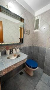 y baño con aseo azul y espejo. en Depto 3 Amb en Palermo Piso Alto en Buenos Aires