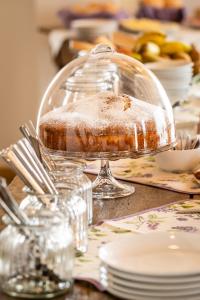 einen Kuchen in einem Glasgericht auf einem Tisch in der Unterkunft Agriturismo al Comarel in Tarzo + 26 Fotos