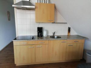 a small kitchen with a sink and a staircase at Uut in Thuus in Buren