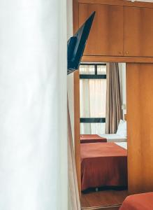 a bedroom with two beds and a mirror at Hotel Mar Azul in Espinho