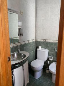 a bathroom with a toilet and a sink and a mirror at Hotel Mar Azul in Espinho