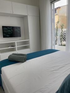 1 dormitorio con 1 cama blanca y TV en Windsurf Beach Front en Torre Grande