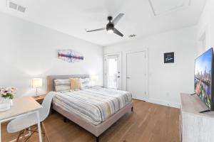 a white bedroom with a bed and a desk at Luxe East Downtown 3BR Condo, Walk to Bars, Restaurants, Shops in Austin