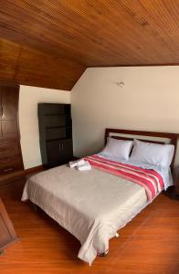 Cette chambre comprend un grand lit et un plafond en bois. dans l'établissement CASA BLANCA, à Sogamoso