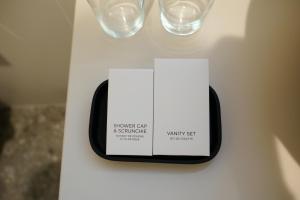 a white sign on a table with glasses on it at Bloom Hotel in Ljubljana