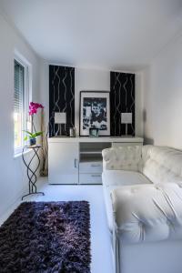 バラトンケネシェにあるFekete Orchidea Apartmanのリビングルーム(白いソファ、テーブル付)