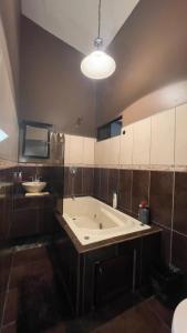 a large bath tub in a bathroom with a sink at Around Juan Santa María in Alajuela City