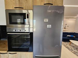 een keuken met een koelkast en een magnetron bij Tower Bridge Apartment in Tirana