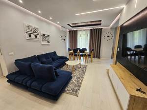 a living room with a blue couch and a table at Tower Bridge Apartment in Tirana