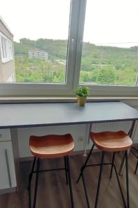 a counter with two stools in front of a window at Schöne Wohnung mit Balkon/Parkplatz/Aufzug in Hagen