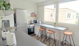 a kitchen with a counter and stools in it at Schöne Wohnung mit Balkon/Parkplatz/Aufzug in Hagen +4 photos