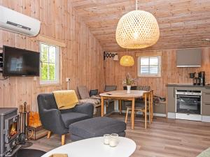 a living room with a table and chairs and a television at 4 person holiday home in Hemmet in Hemmet