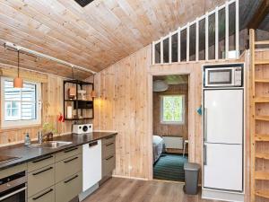 a kitchen with wooden walls and a refrigerator at 4 person holiday home in Hemmet in Hemmet