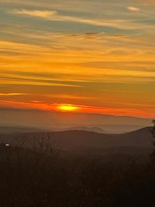 una puesta de sol con la puesta de sol sobre las montañas en Hidden Views A Duplex, en Twain Harte