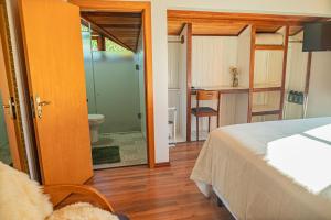 a bedroom with a bed and a bathroom with a toilet at Casarão do Vale dos Vinhedos in Bento Gonçalves