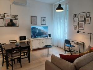 a living room with a television and a table and chairs at Apartment Calliope in Zagreb
