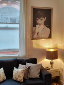 a living room with a couch and a picture of a woman at John Street Apartments Flat 2 in Bristol